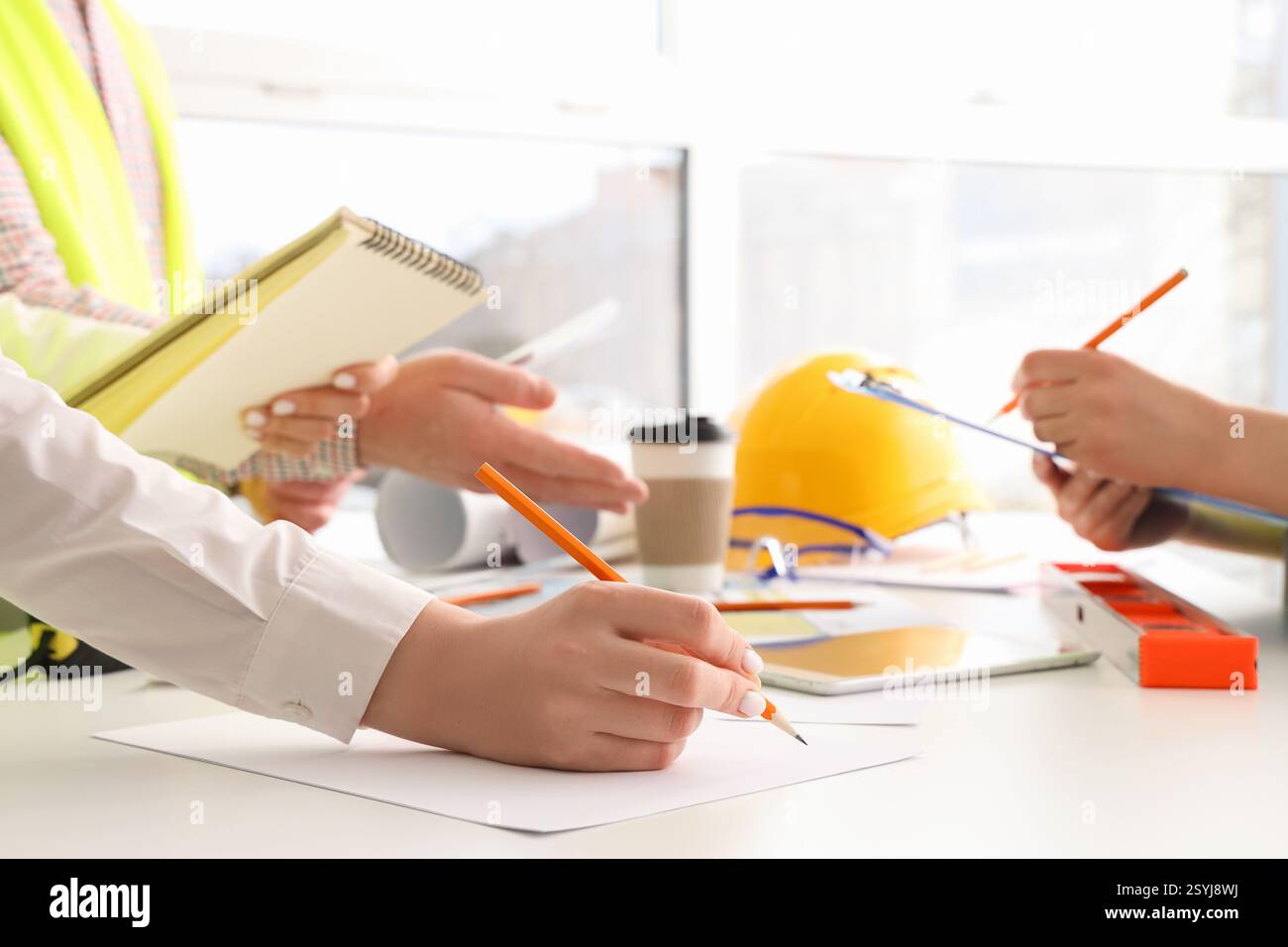 Team of constructors working at table in room, closeup Stock Photo
