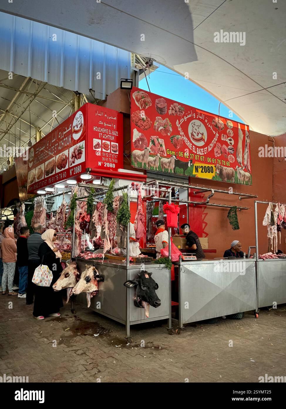 View of butchers, with cow heads on display, inside the Souk El Had, Agadir, Morocco. - Smartphone Captured Stock Image
