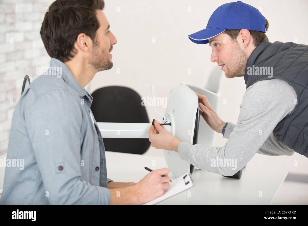 2 concentrated men in fixing a chair Stock Photo