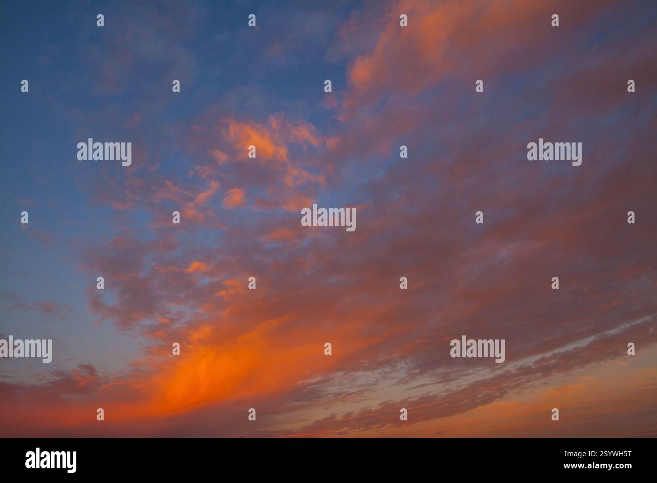 A vibrant sunset sky with dramatic clouds in shades of orange, pink ...