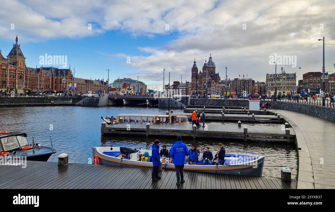 Amsterdam, Netherlands - December 3,  2024: Passenger boat pier for tourists onboarding the ferry for canal trip sightseeing. - Smartphone Captured Stock Image