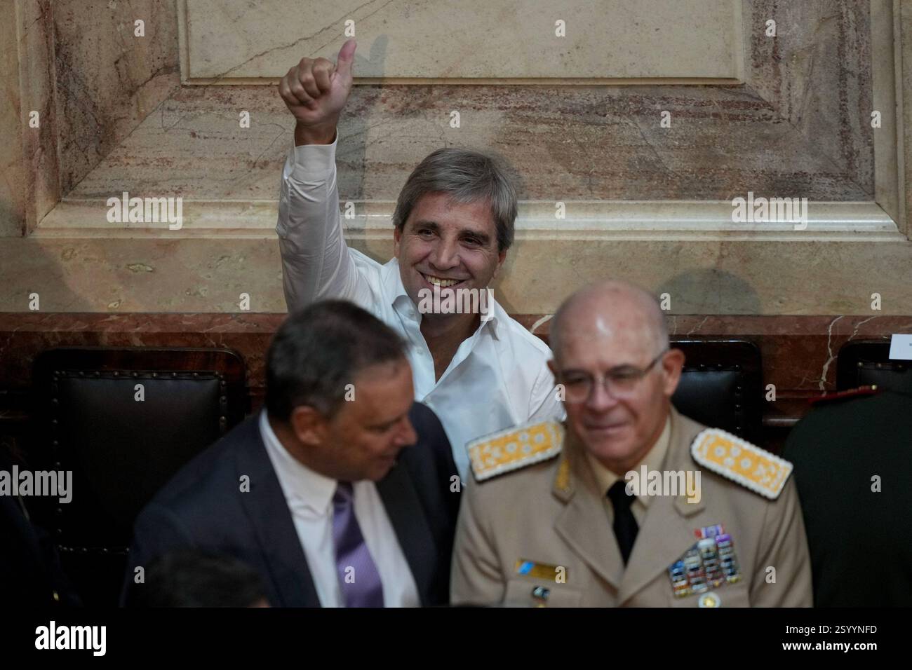 Economy Minister Luis Caputo flashes a thumb up as he waits for ...
