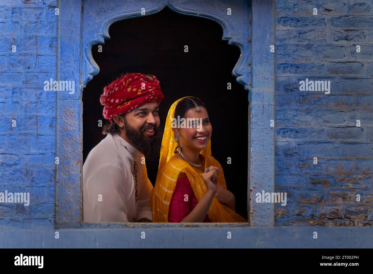 Young couple looking out through window Stock Photo