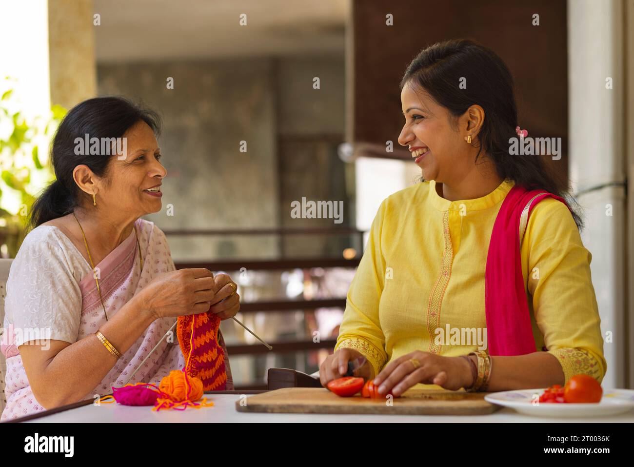 Motherinlaw and daughterinlaw talking while doing housework on