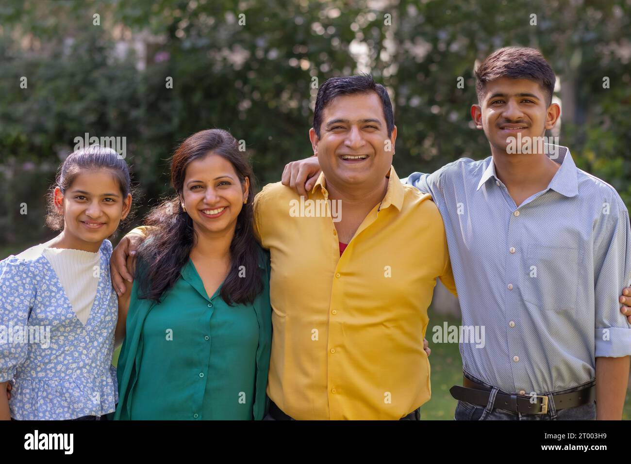 Portrait of happy Indian family standing together in backyard Stock ...