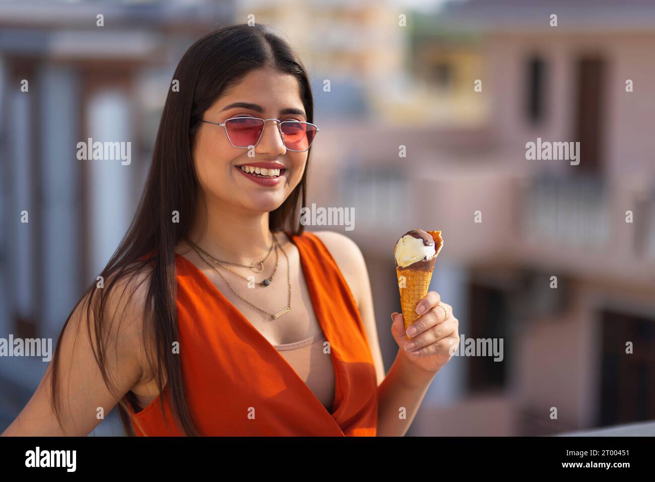 Portrait of young woman eating ice cream in cone Stock Photo