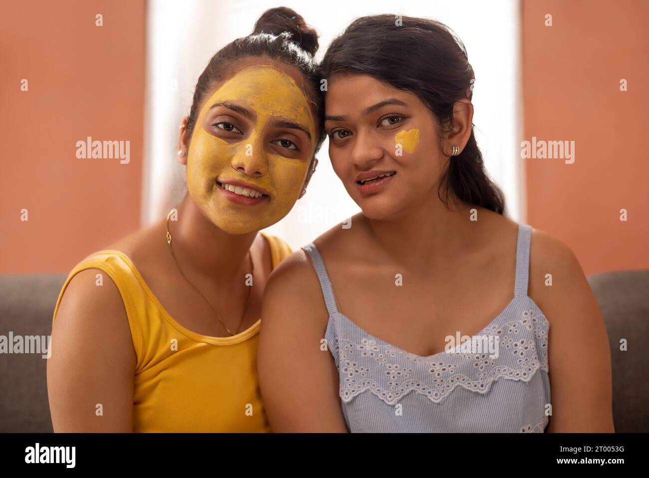 Portrait of two women with turmeric face pack Stock Photo