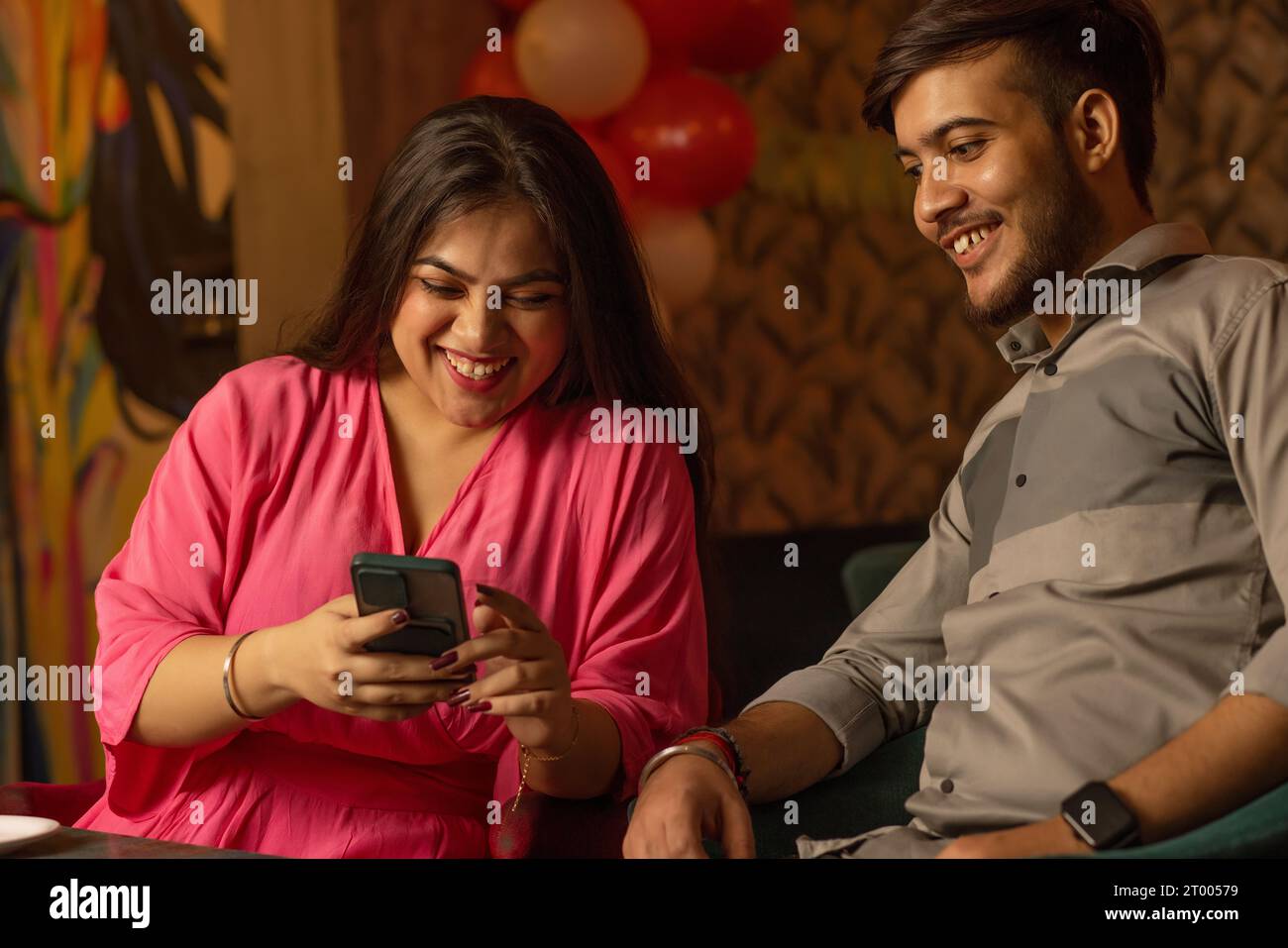 Friends using mobile phone while sitting at restaurant Stock Photo