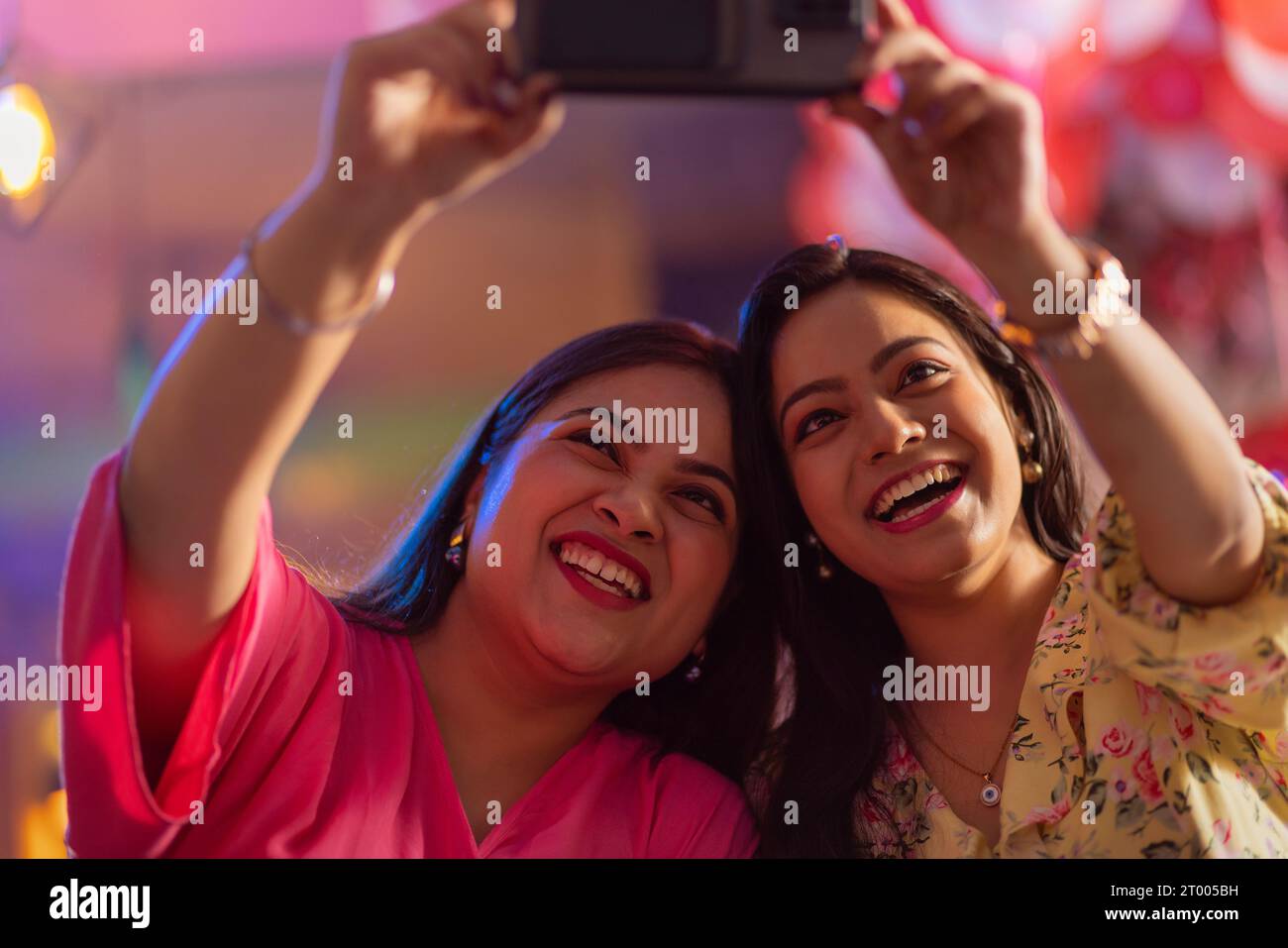 Women taking selfie on mobile phone at restaurant Stock Photo
