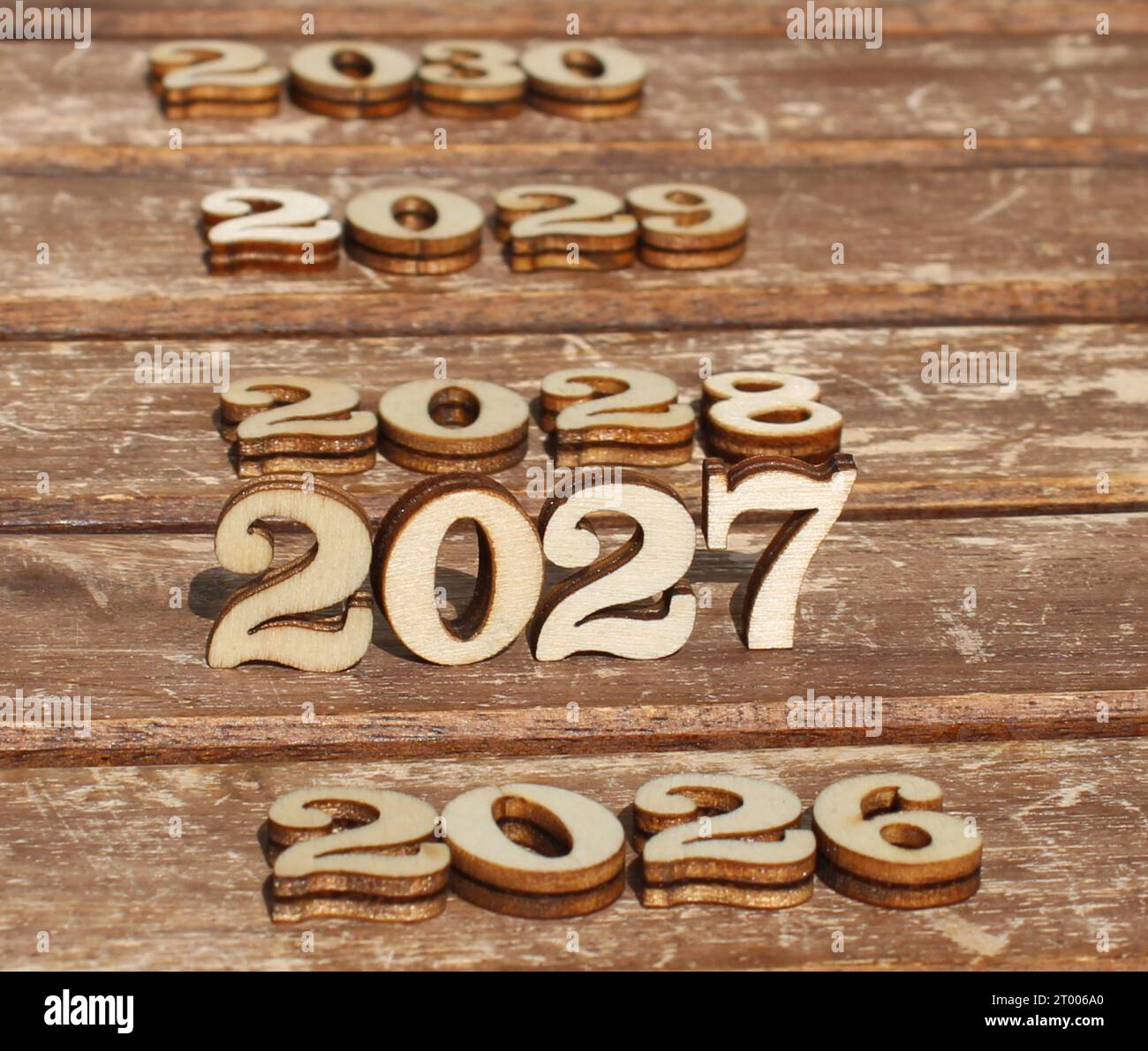 nature wooden numbers in the sun on a sunny day.  create 2027 with 2026 and 2028 2029 2030. background is made from naturally wood for happy new year Stock Photo