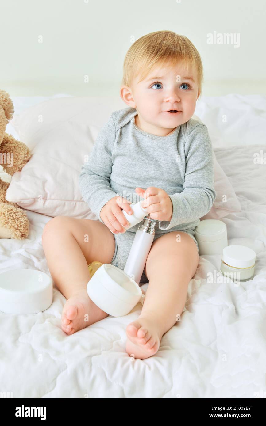 Beautiful little girl, toddler with blue eyes sitting in bed around
