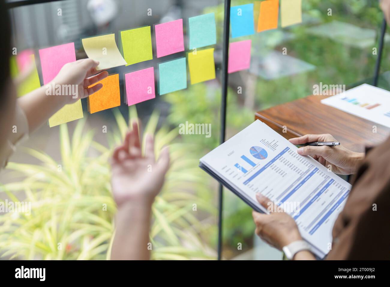 Business People working on sticky notes creative writing down ideas on post it notes professional investor start up project busi Stock Photo
