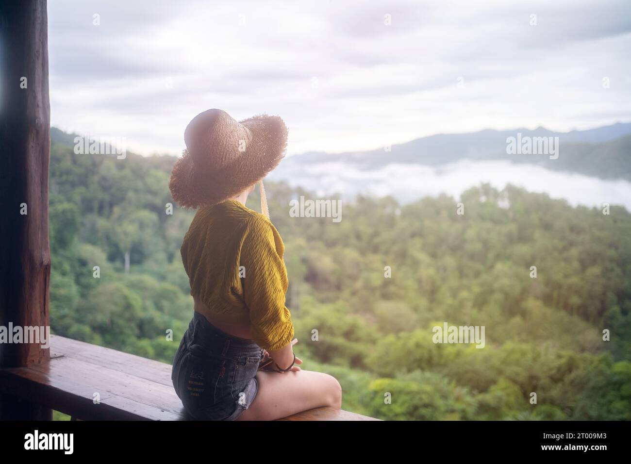 Carefree happy woman in morning of nature cliff mountain. Woman travel tourist alone morning freedom and happiness Stock Photo