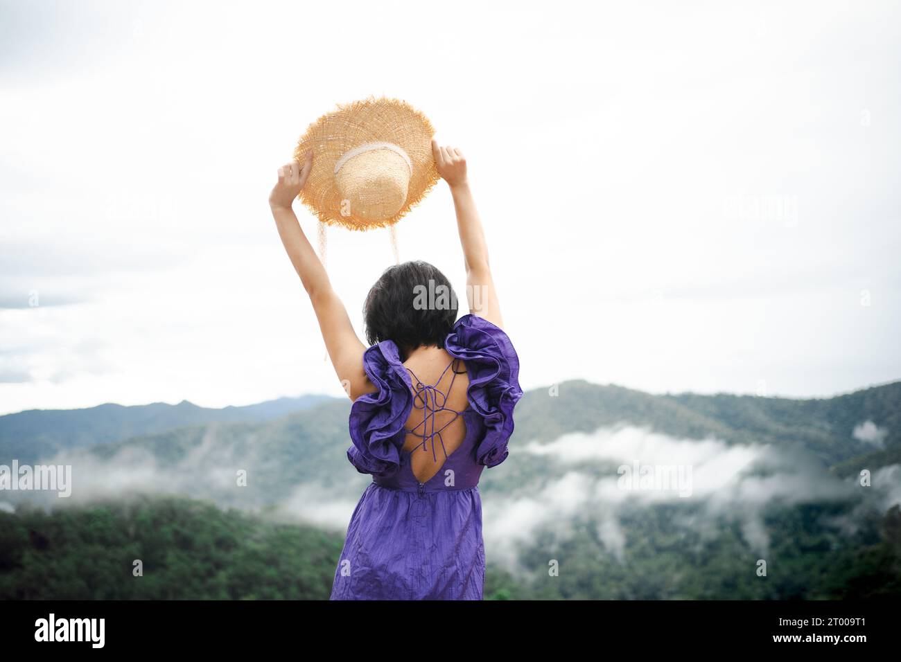 Carefree happy woman in morning of nature cliff mountain. Woman travel tourist alone morning freedom and happiness Stock Photo