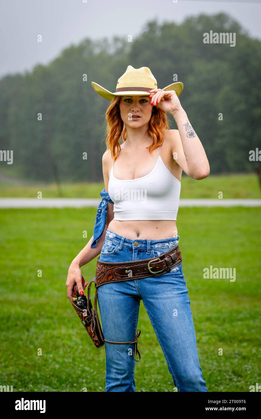 A Lovely Red Headed Country Wetern Model Poses Outdoors In A Country Setting Stock Photo