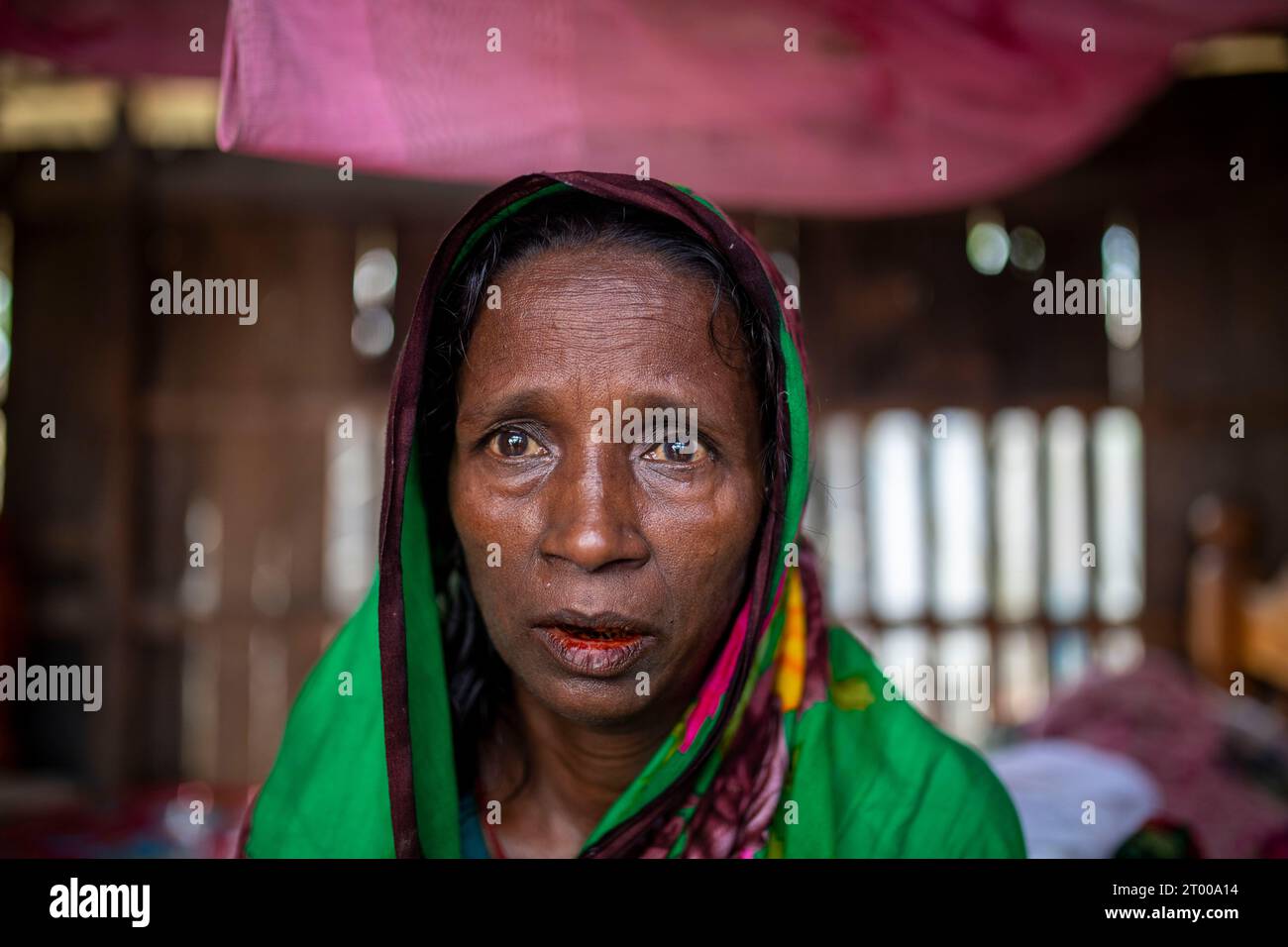 Mosammat Rashida sits inside her house destroyed by Cyclone Bulbul at