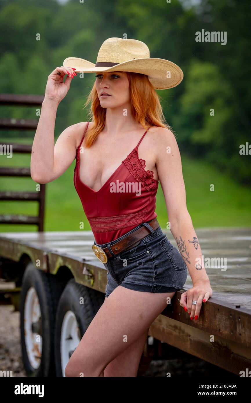 A Lovely Red Headed Country Wetern Model Poses Outdoors In A Country Setting Stock Photo