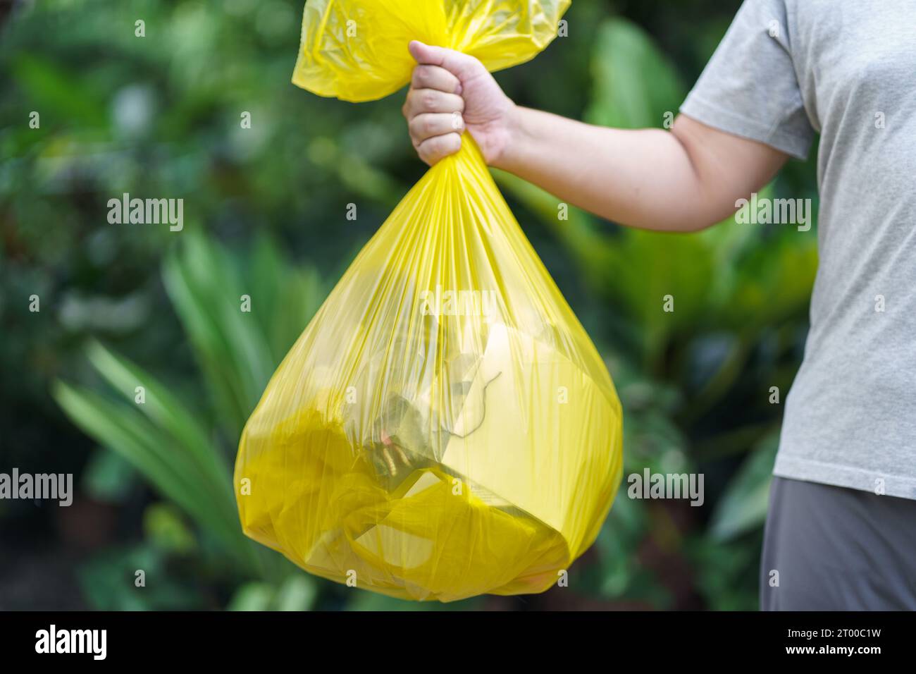 Man Volunteer charity holding garbage yellow bag and plastic bottle