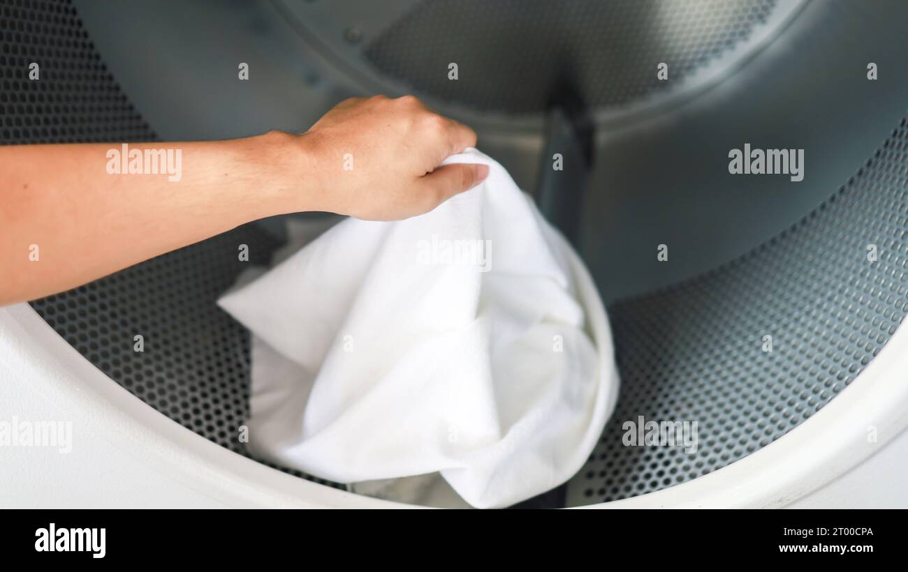 Man doing launder holding basket with dirty laundry of the washing machine in the public store. laundry clothes concept Stock Photo
