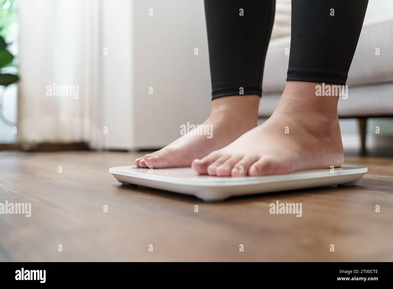 Woman bare feet standing on a digital scale with body fat analyzer that  uses bioelectrical impedance (BIA) to gauge the amount of fat in your body  Stock Photo