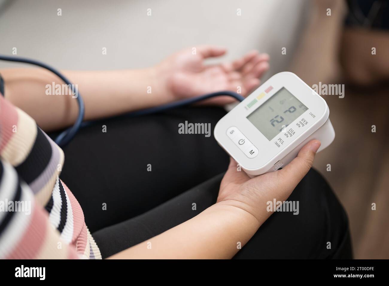 Woman Overweight plus size self checks measuring blood pressure and
