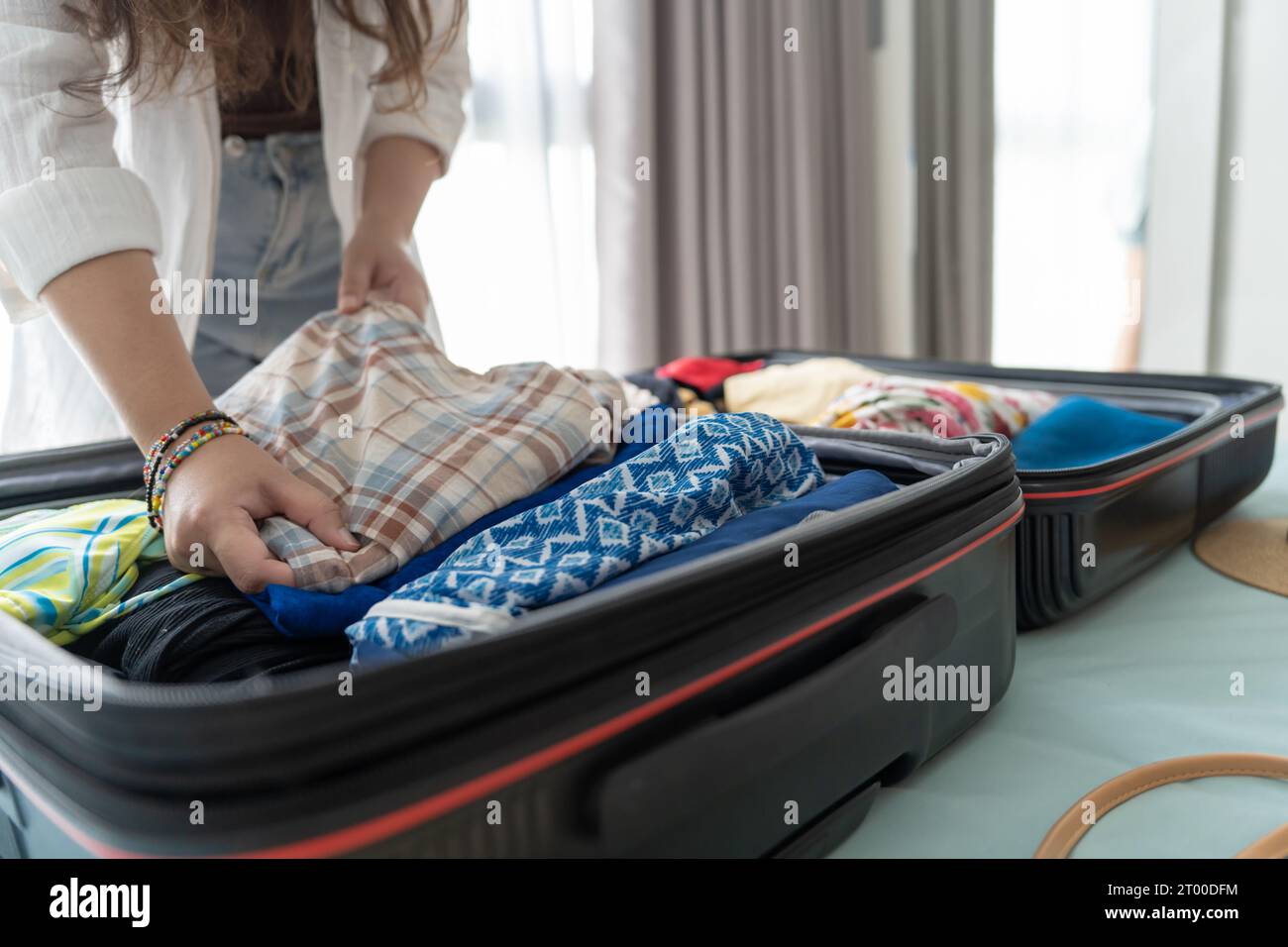 Woman packing suitcase on bed for a new journey packing list for travel