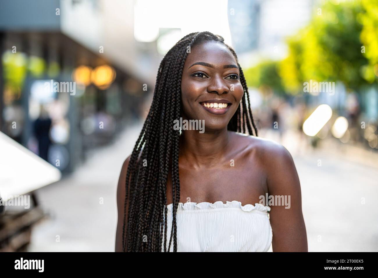 Portrait of a beautiful young woman smiling in the city Stock Photo - Alamy