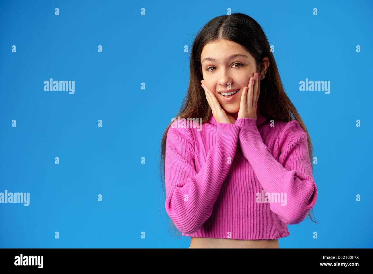 Happy teenager, positive smiling girl on blue background in studio ...