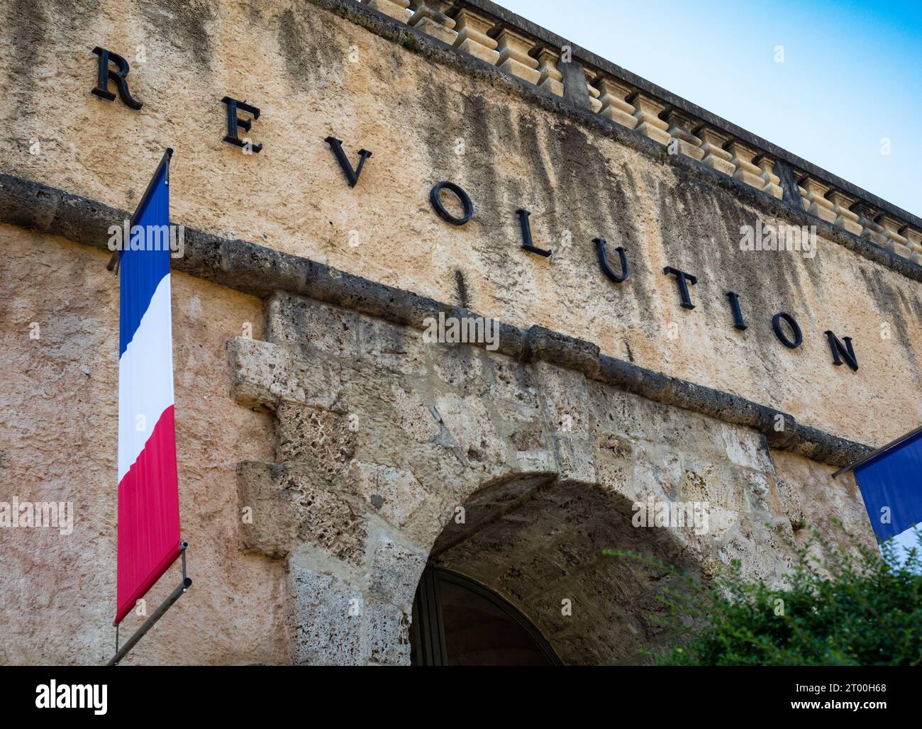 The word "Revolution" and a French flag above the main entrance to the