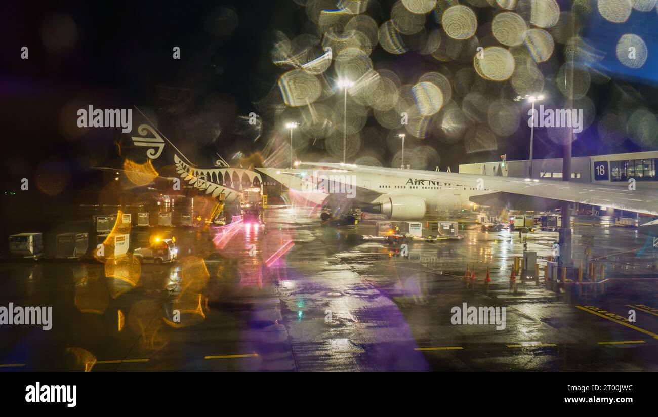 Window view of An Air New Zealand airplane in the rain. Auckland International Airport Stock Photo