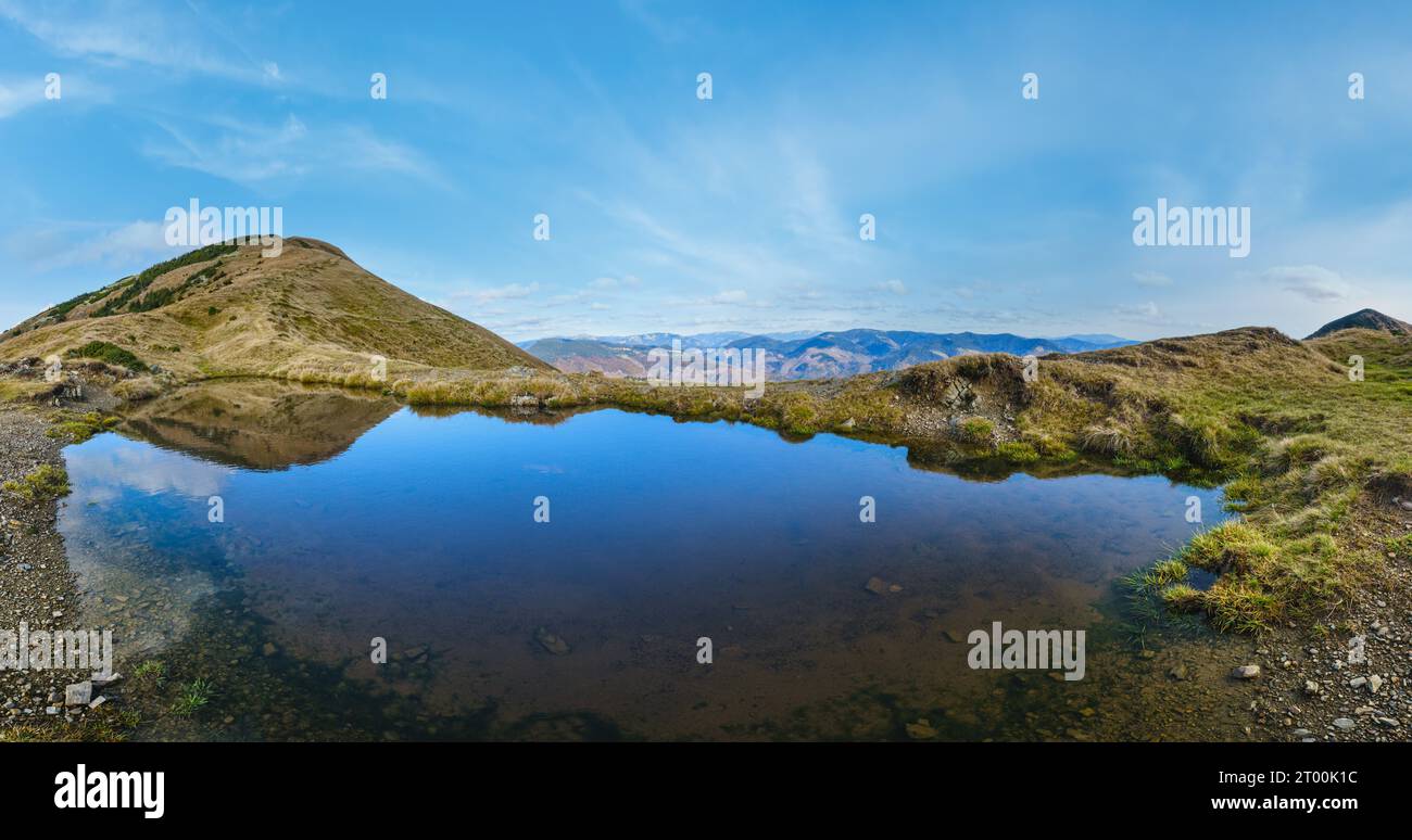 Small picturesque lake with clouds reflections at the  Strymba Mount. Beautiful autumn day in Carpathian Mountains near Kolochav Stock Photo