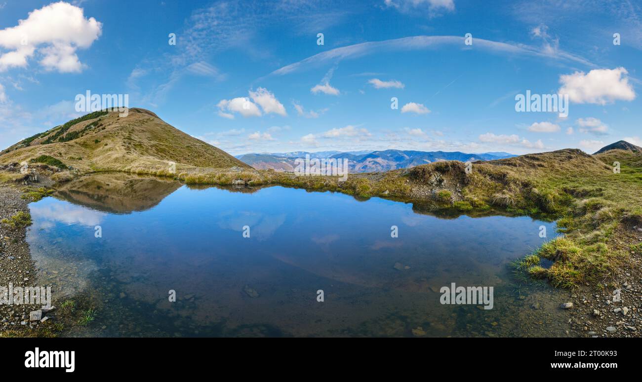 Small picturesque lake with clouds reflections at the  Strymba Mount. Beautiful autumn day in Carpathian Mountains near Kolochav Stock Photo