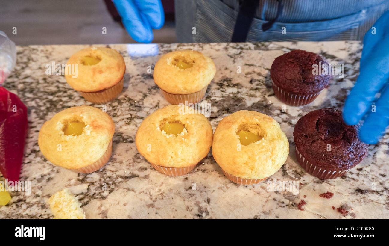 Filling Vanilla, Chocolate Cupcakes with Lemon, Raspberry Stock Photo