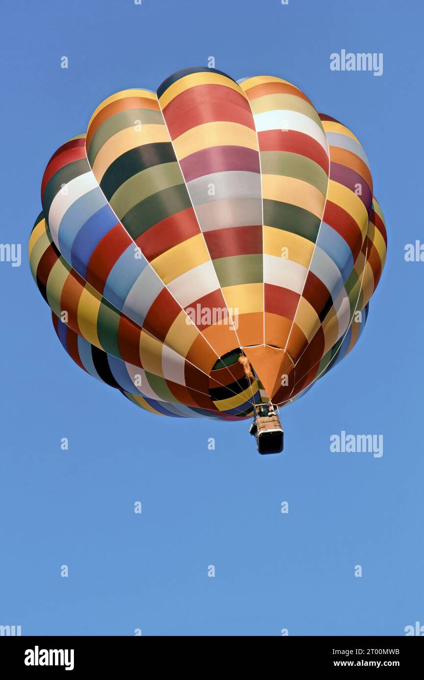 multicolored hot air balloon in flight in a clear sky Stock Photo