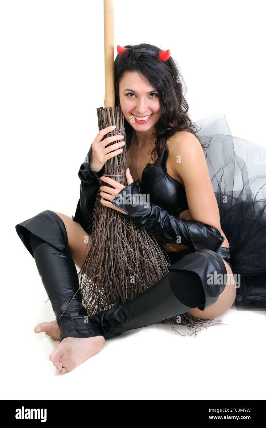 portrait of young attractive woman in devil costume with broom in the halloween party on  white background Stock Photo