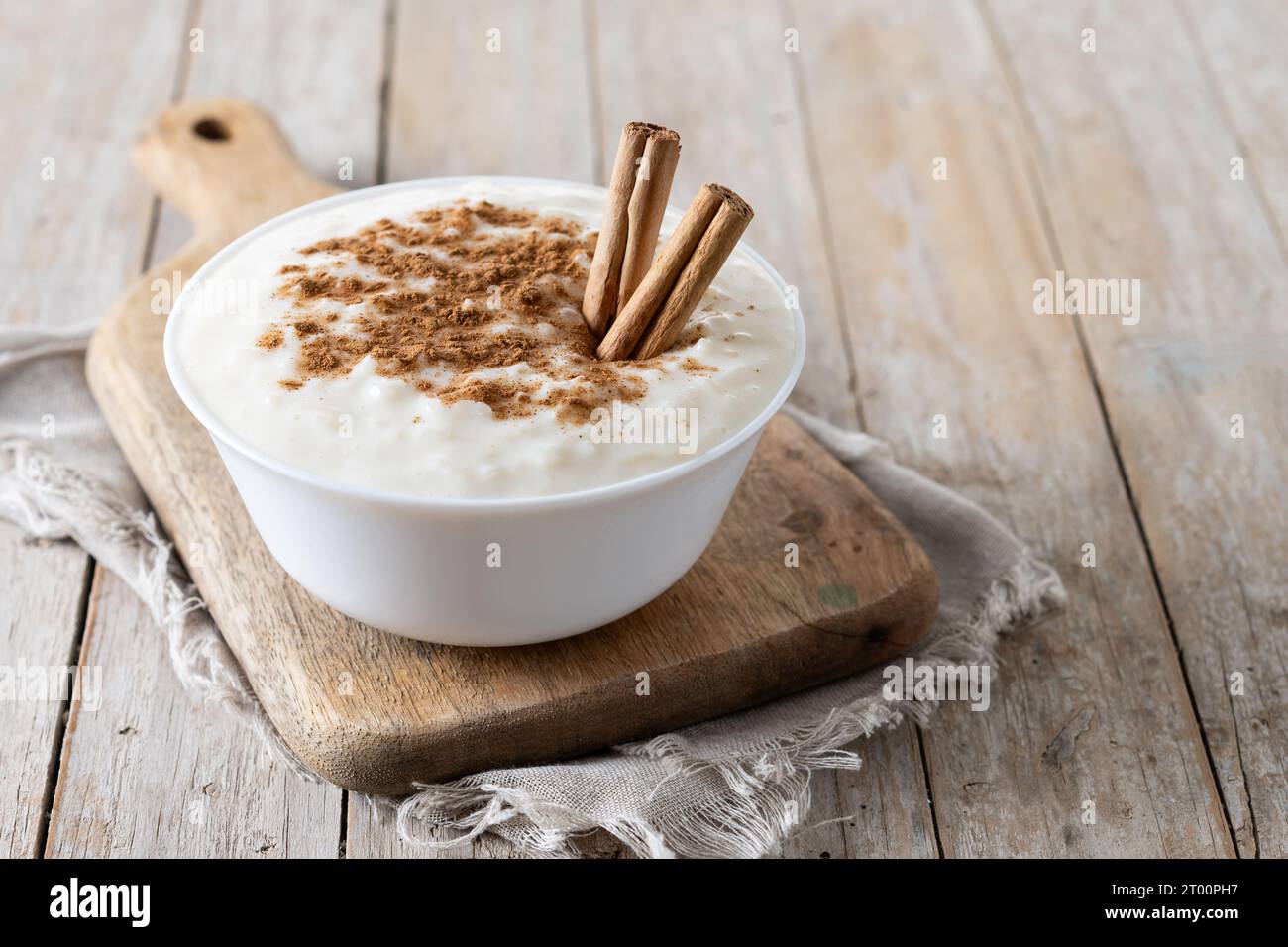 Arroz con leche. Rice pudding with cinnamon in bowl on wooden table Stock Photo