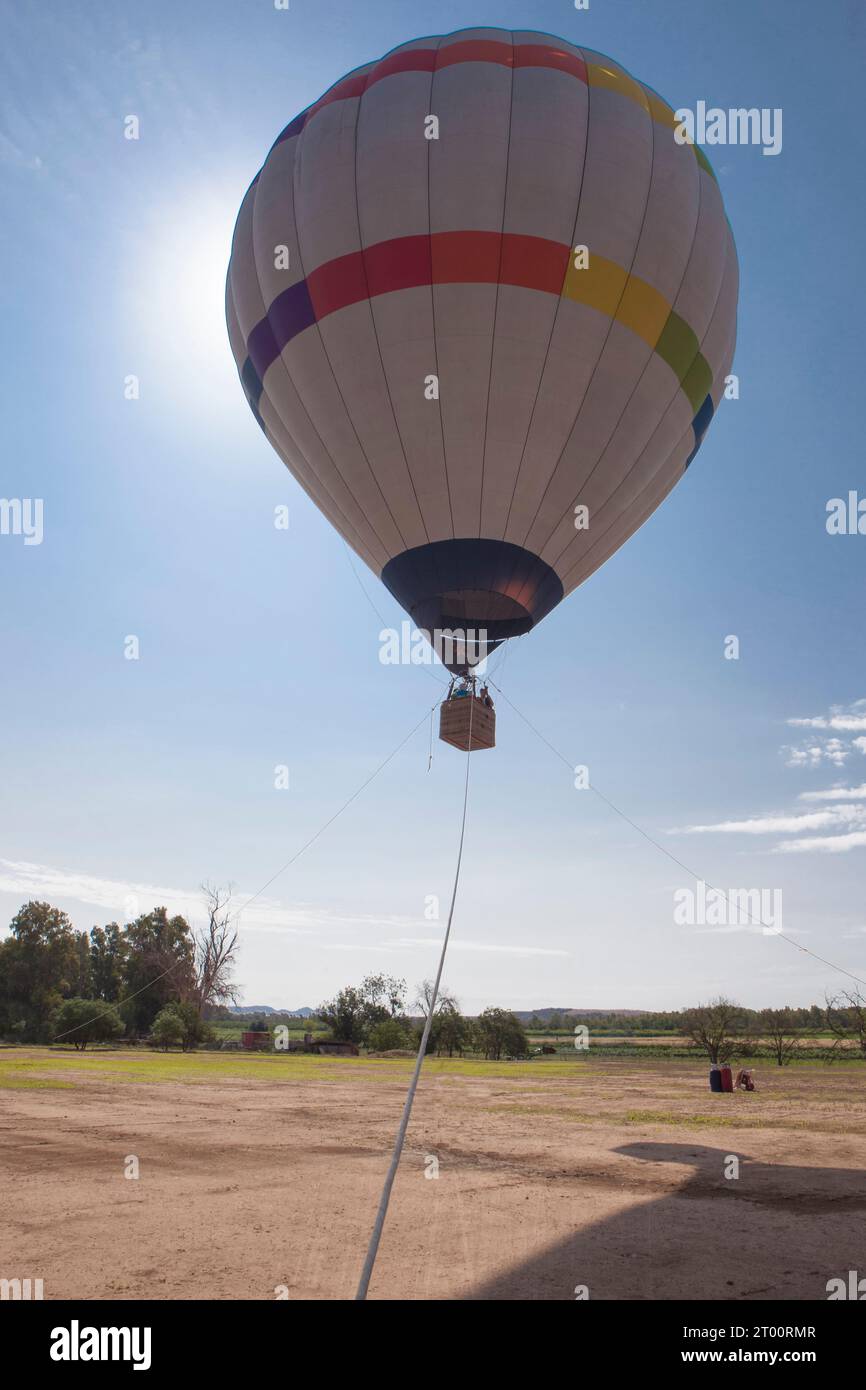 Ascending hot air balloon. Air-vehicle tethered to three fixed points Stock Photo