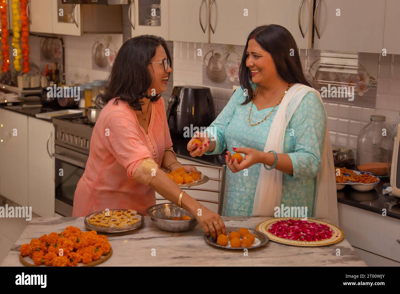 Mother in law and daughter in law making Ladoo on the occasion of Diwali Stock Photo