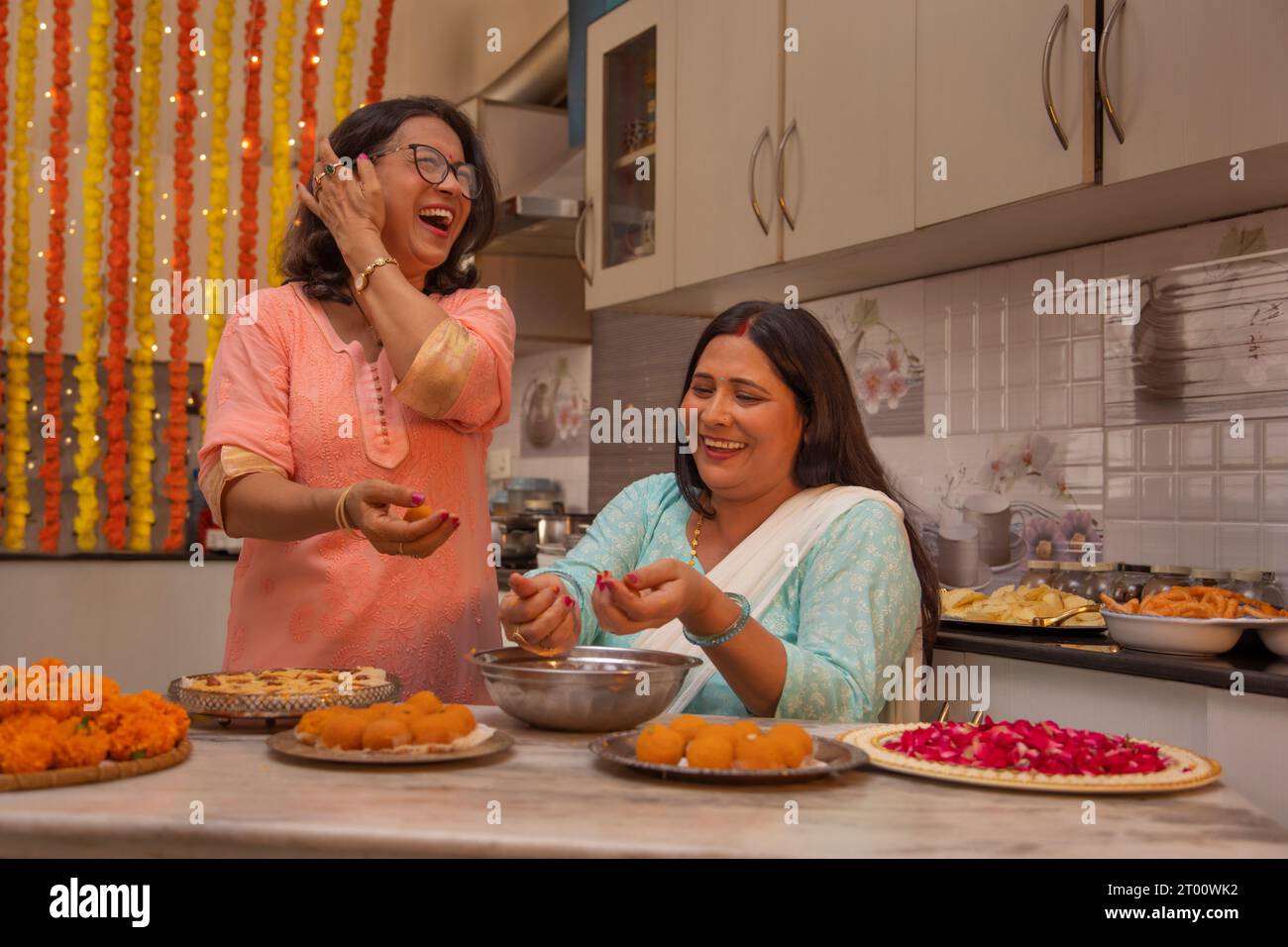 Sister in laws teaching eachother, how to make Ladoos ( Traditional