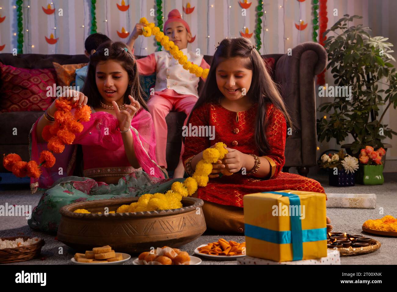 Group of children making garlands with flowers during Diwali celebration Stock Photo