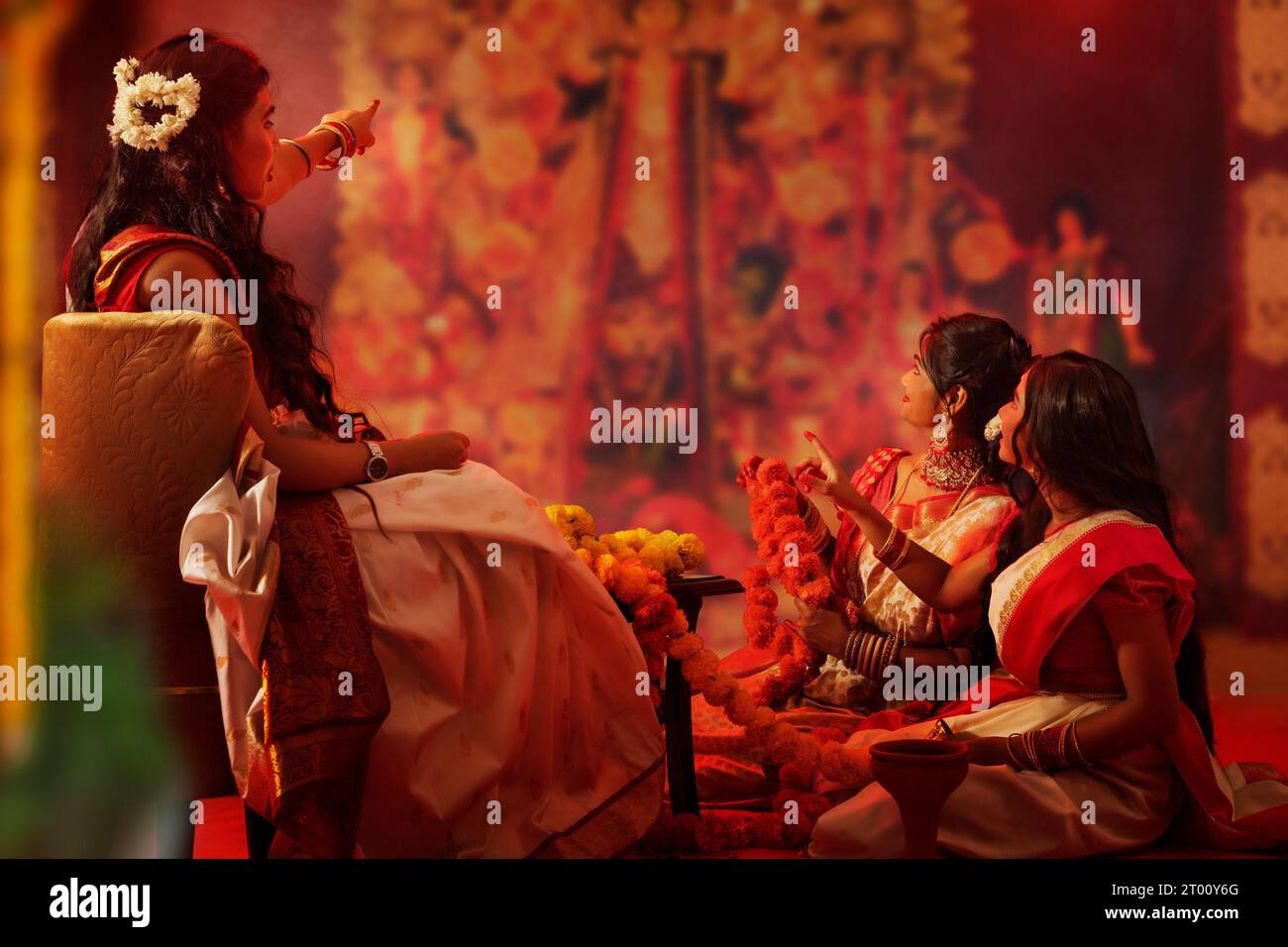 Bengali family making flower garland on the occasion of Durga Puja