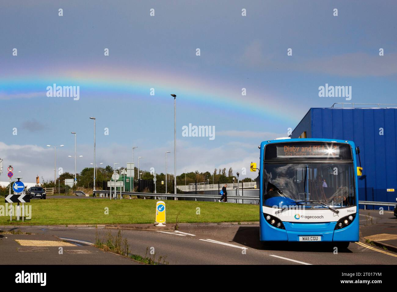 local Exeter Stagecoach bus on roundabout for Digby and Ikea to city centre against rainbow in the sky and Ikea building in the background Stock Photo