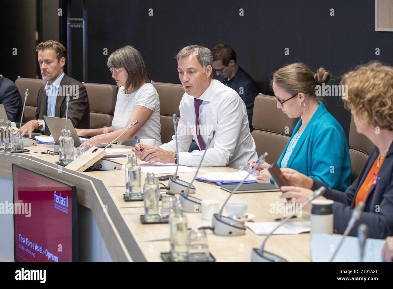 Prime Minister Alexander De Croo (3L), State Secretary for Asylum and Migration policy Nicole de Moor and Vice-prime minister and minister of Civil Services and State-owned companies Petra De Sutter pictured during a meeting of the federal government task force responsible for finding 2,000 temporary places to house asylum seekers, in Brussels, Tuesday 03 October 2023. This is the first meeting of the task force, several administrations and agencies are taking part, including the Federal Agency for the Reception of Asylum Seekers Fedasil, the Ministry of Defense, the Federal Public Health Serv Stock Photo