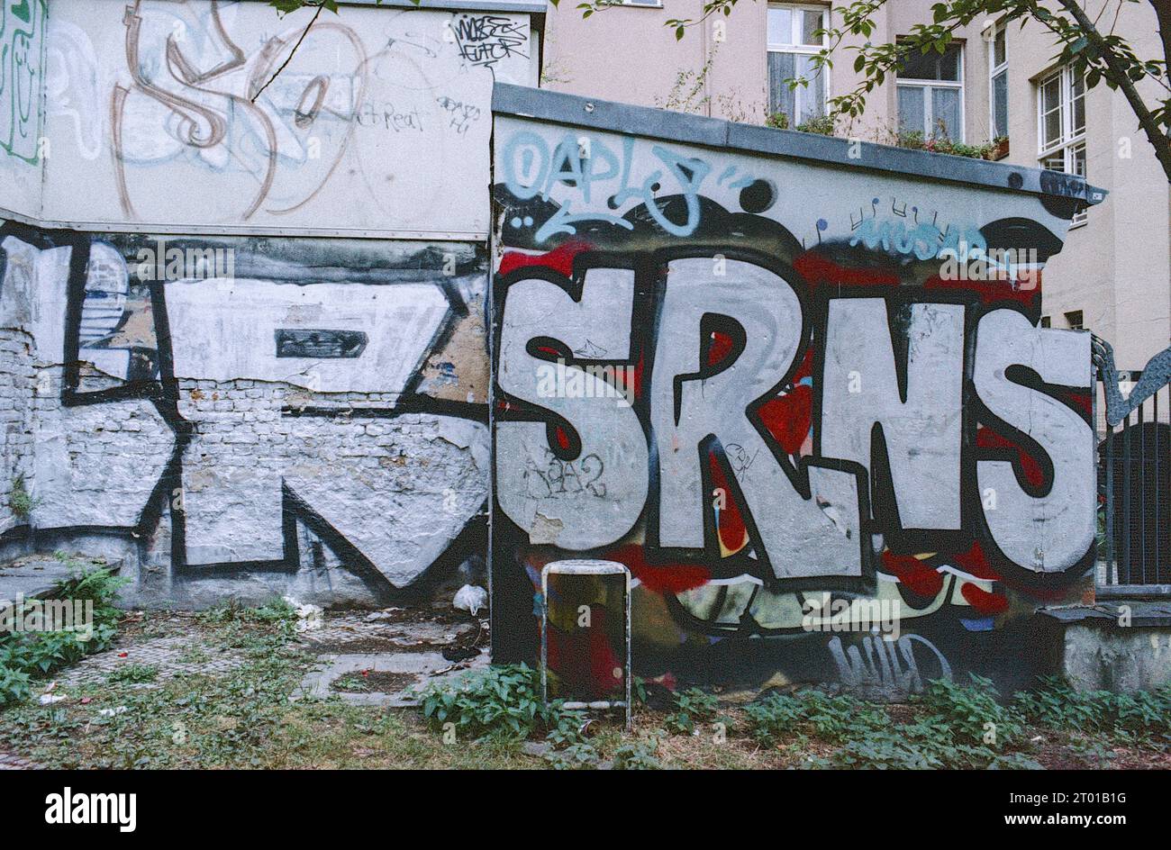 Urban Graffiti in Neighbourhood, to send a message and to decorate otherwise boring, blind walls. Berlin, Germany. Image shot on Analog, Old Stock Kodak Film. Stock Photo