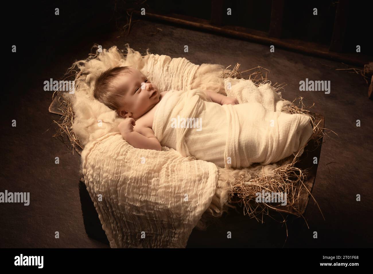 Live Christmas nativity scene of 8 days old baby boy sleeping in a manger Stock Photo
