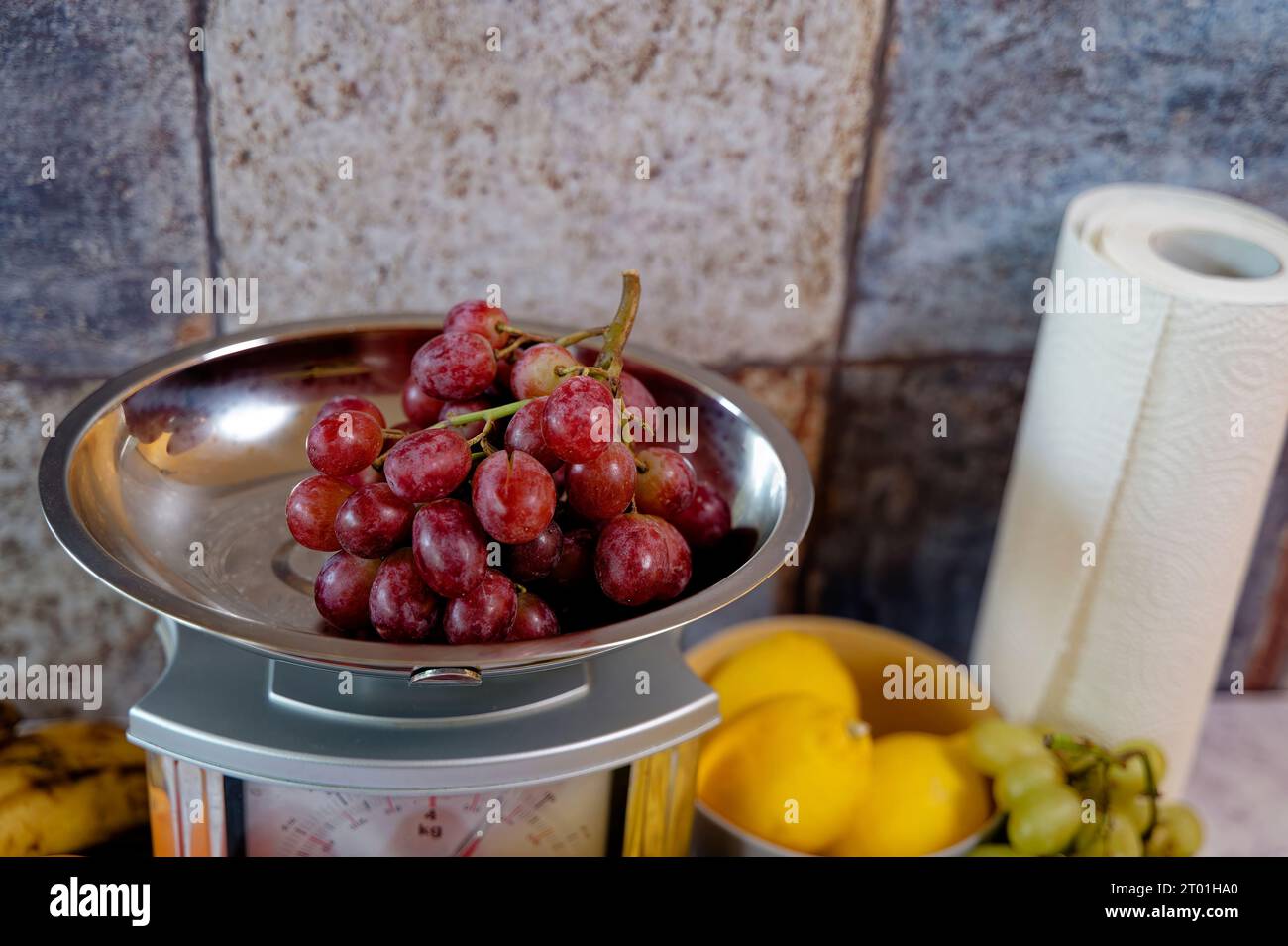 Various fruits on a kitchen countertop and on a kitchen scale. Stock Photo