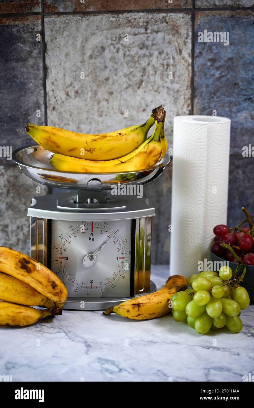 Various fruits on a kitchen countertop and on a kitchen scale. Stock Photo