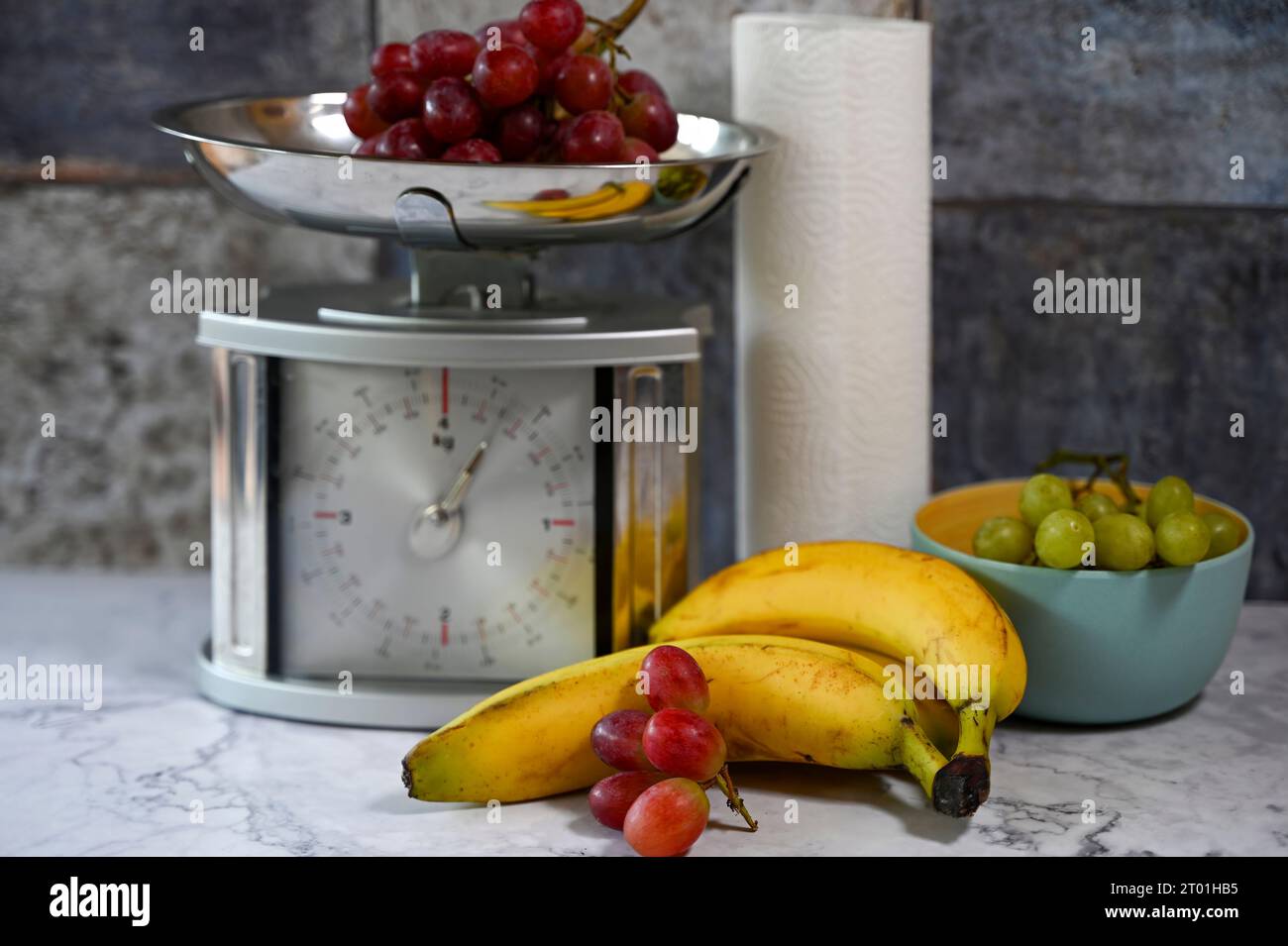 Various fruits on a kitchen countertop and on a kitchen scale. Stock Photo