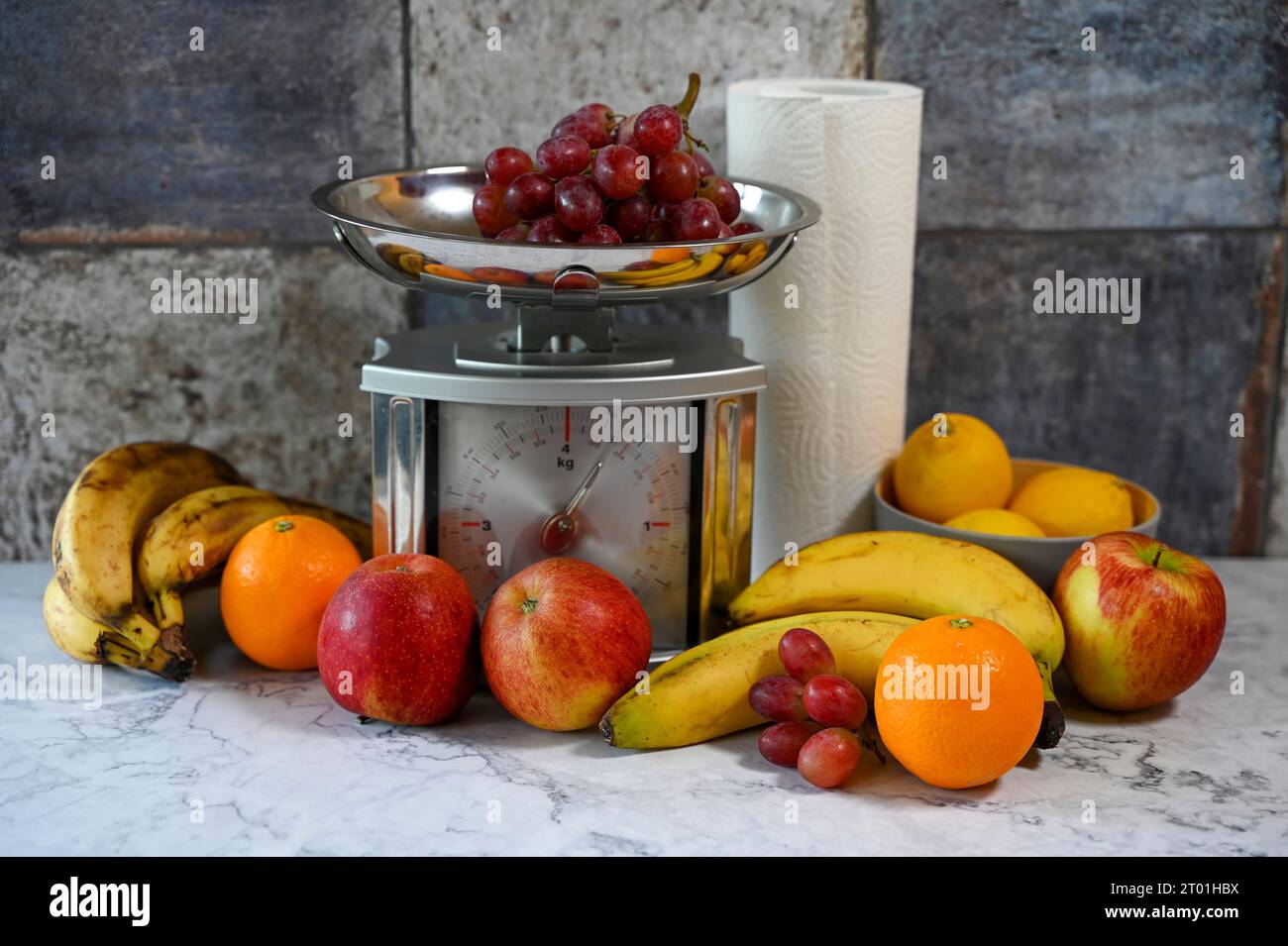 Various fruits on a kitchen countertop and on a kitchen scale. Stock Photo