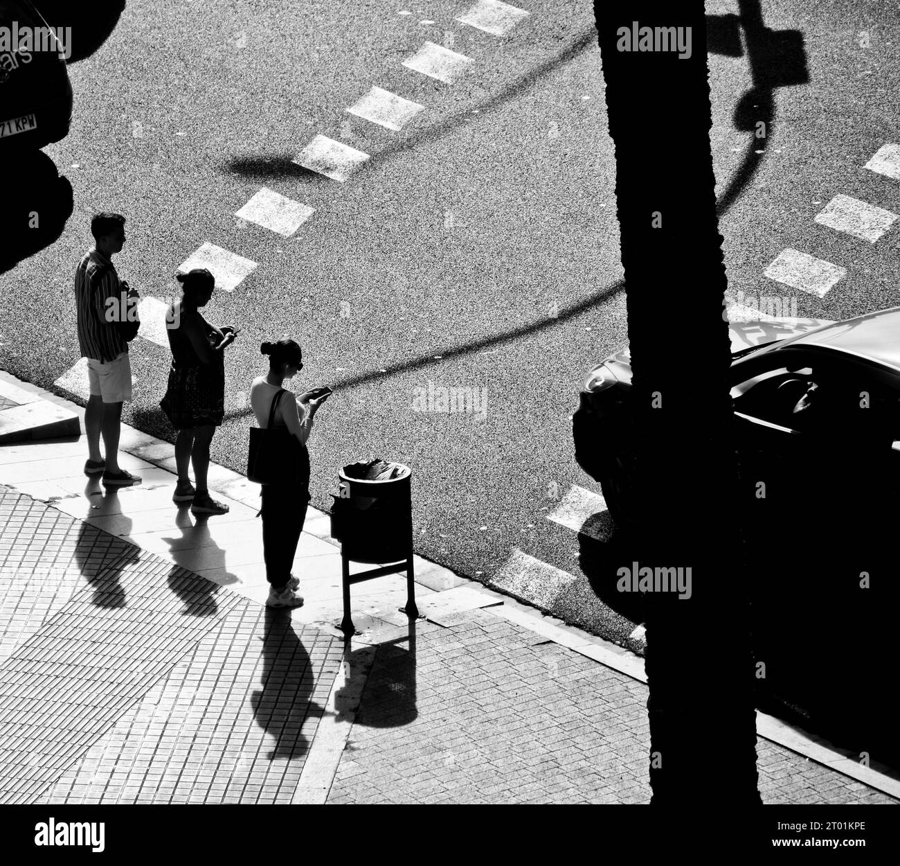 People checking their smartphone while waiting at a traffic light. Stock Photo